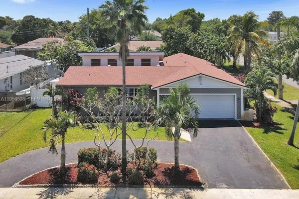 a front view of a house with garden and trees