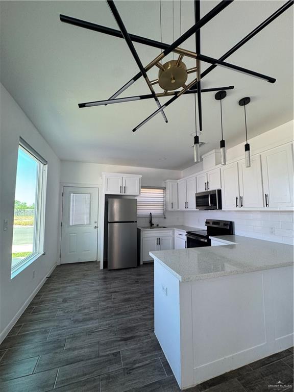 5601 Ozark Avenue, Unit 3 Mission, TX 78573 - Photo 3 of 12 a kitchen with kitchen island white cabinets and stainless steel appliances