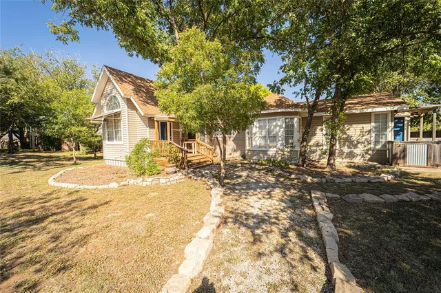 a view of a yard with plants and trees