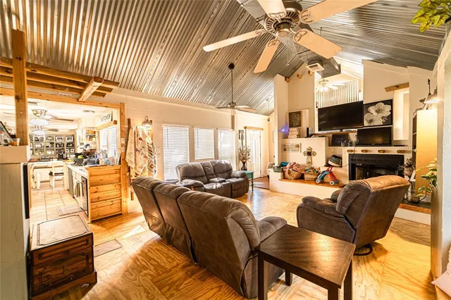 a living room with furniture a flat screen tv and a floor to ceiling window