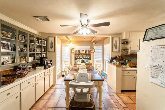 a kitchen with stainless steel appliances kitchen island granite countertop a refrigerator a stove a sink dishwasher and white cabinets with wooden floor