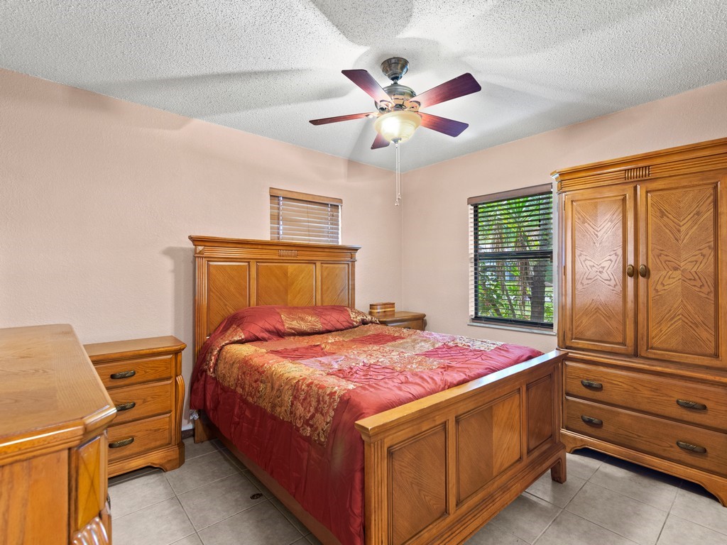 7506 Donlon Road Fort Pierce, FL 34951 - Photo 14 of 23 a bedroom with a bed and a chandelier