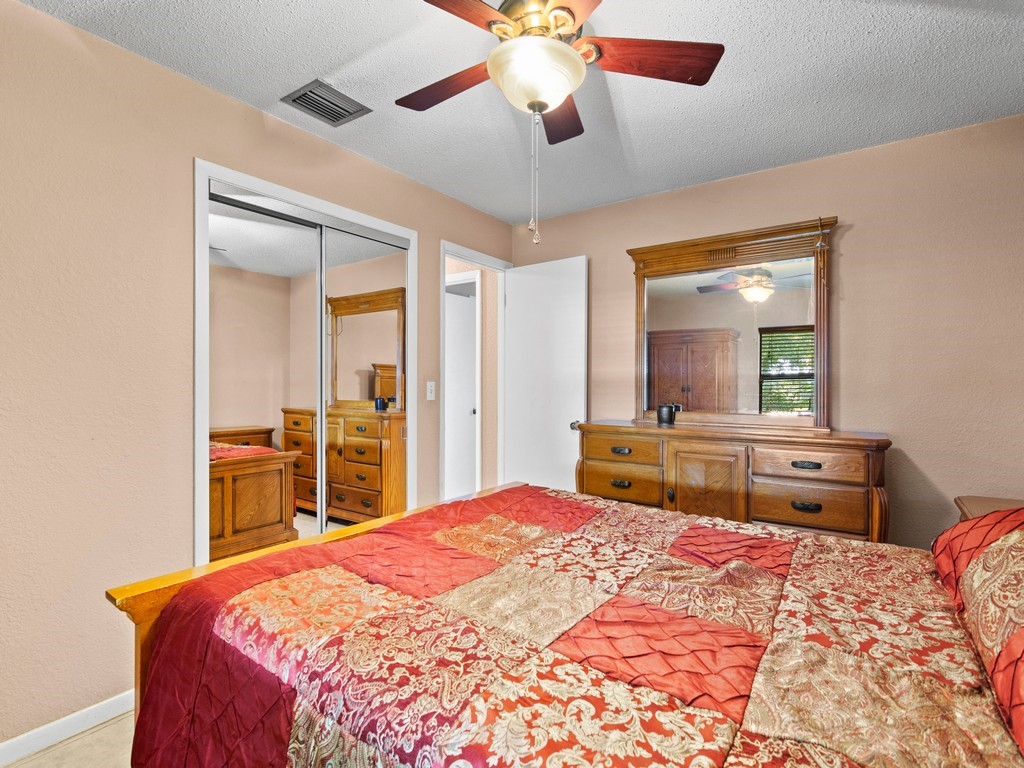 7506 Donlon Road Fort Pierce, FL 34951 - Photo 15 of 23 a bedroom with a large bed and a chandelier