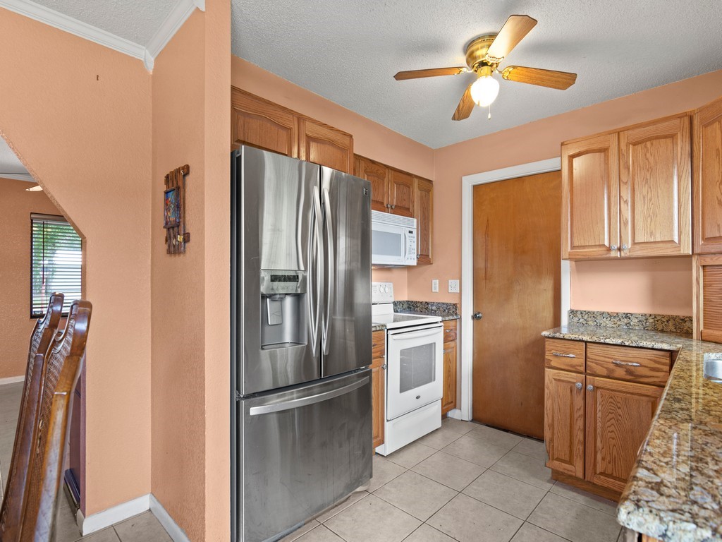 7506 Donlon Road Fort Pierce, FL 34951 - Photo 8 of 23 a kitchen with stainless steel appliances granite countertop a refrigerator a oven a sink and dishwasher