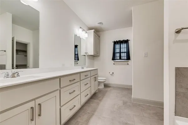 a spacious bathroom with double sink and a mirror