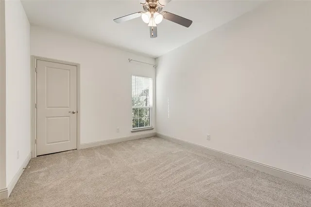 an empty room with fan and windows