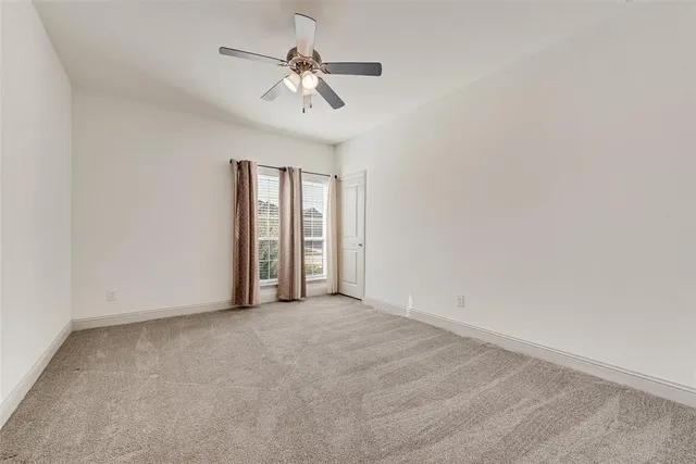 a view of an empty room with a chandelier fan