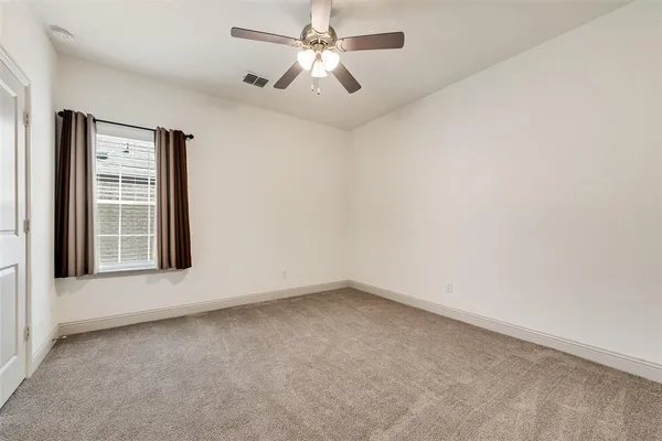 an empty room with a window and a ceiling fan