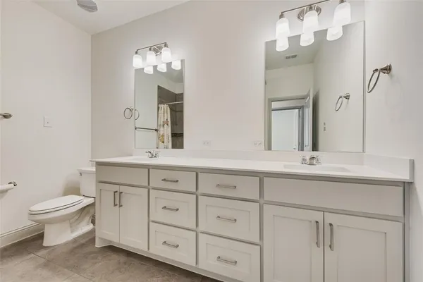 a bathroom with a double vanity sink and a toilet