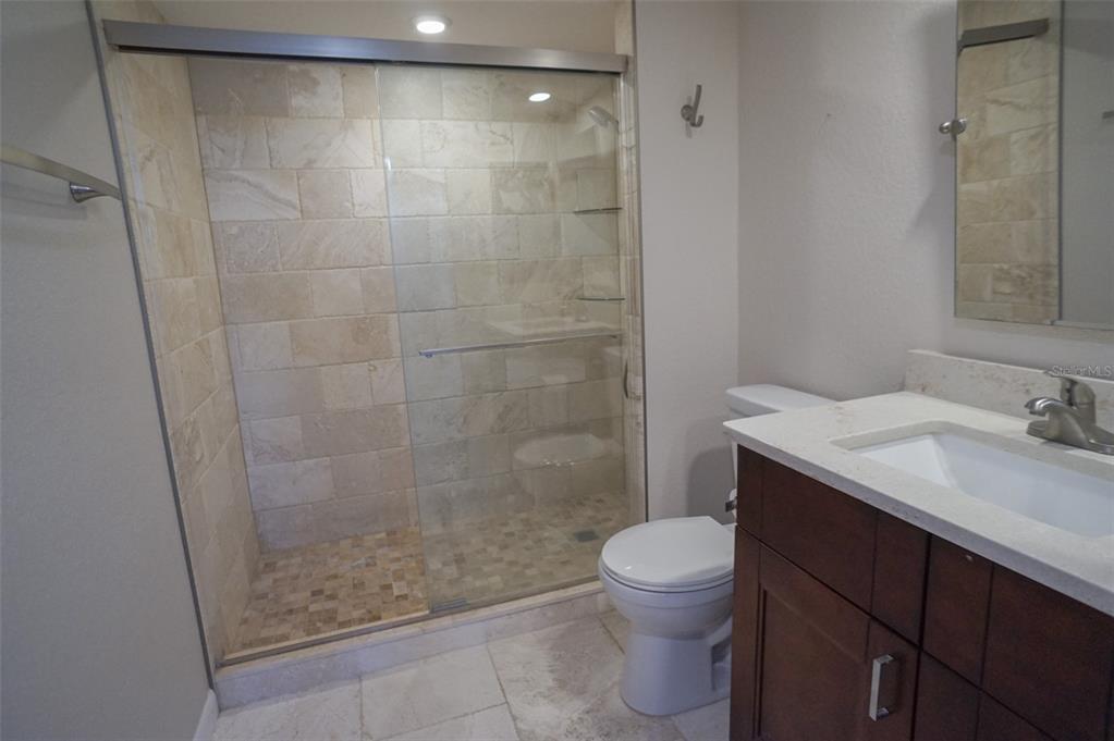 400 Island Way, Unit 308 Clearwater, FL 33767 - Photo 12 of 32 a bathroom with a sink a toilet and shower