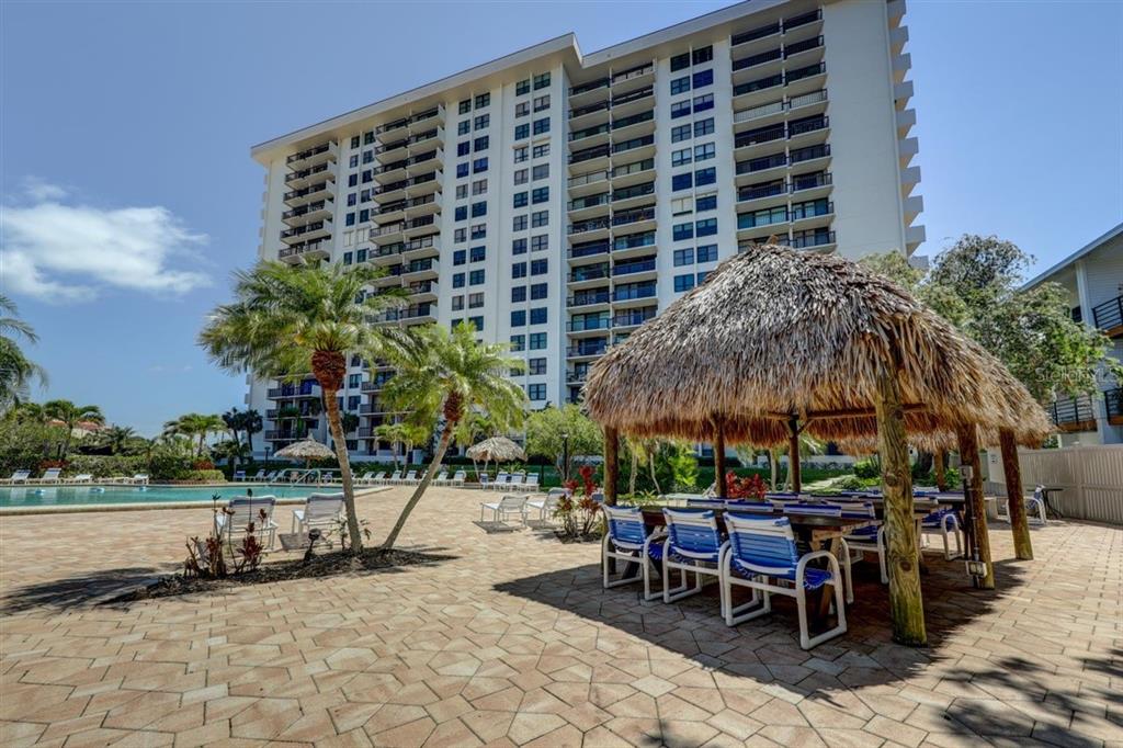 400 Island Way, Unit 308 Clearwater, FL 33767 - Photo 24 of 32 a view of a patio with a table and chairs under an umbrella
