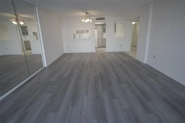 an empty room with wooden floor and entrance
