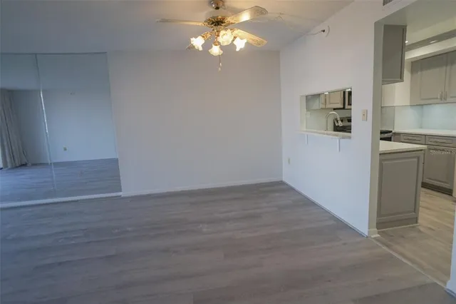 a view of a kitchen with wooden floor and a ceiling fan