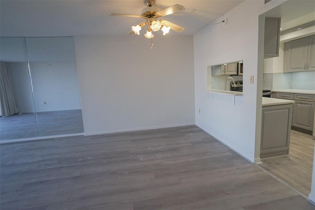400 Island Way, Unit 308 Clearwater, FL 33767 - Photo 10 of 32 a view of a kitchen with wooden floor and a ceiling fan