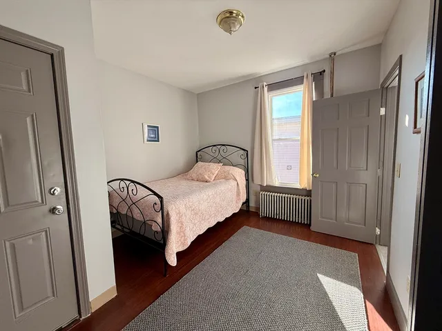 a bedroom with a bed table and a window