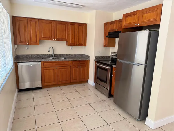 a kitchen with stainless steel appliances granite countertop a refrigerator stove and sink