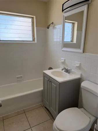 a bathroom with a sink vanity mirror and toilet