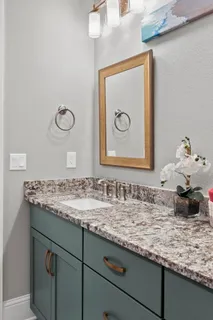 a bathroom with a granite countertop sink a toilet and mirror