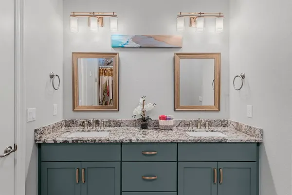 a bathroom with a granite countertop sink a mirror and a shower