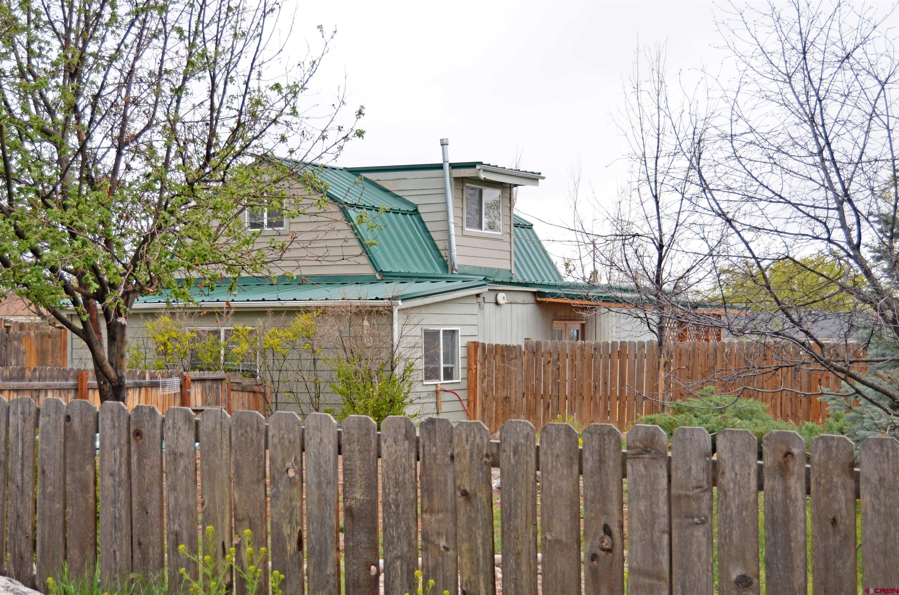a view of a house with wooden fence