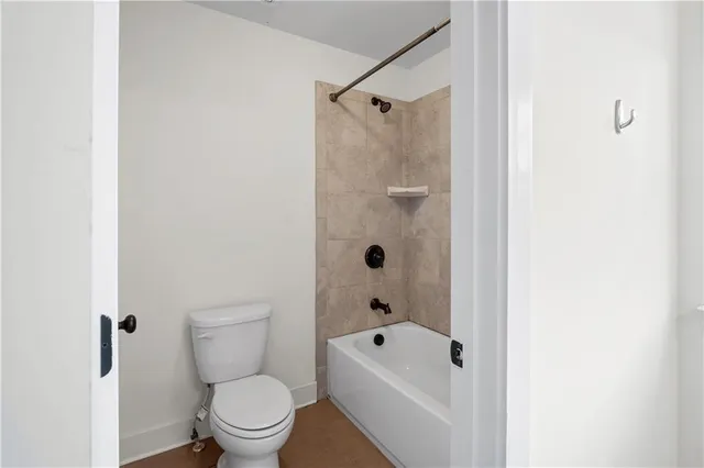 a white toilet sitting next to a bathroom sink and a shower