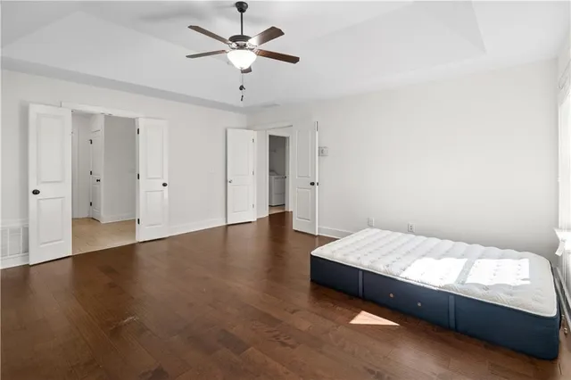 a spacious bedroom with a bed and a chandelier