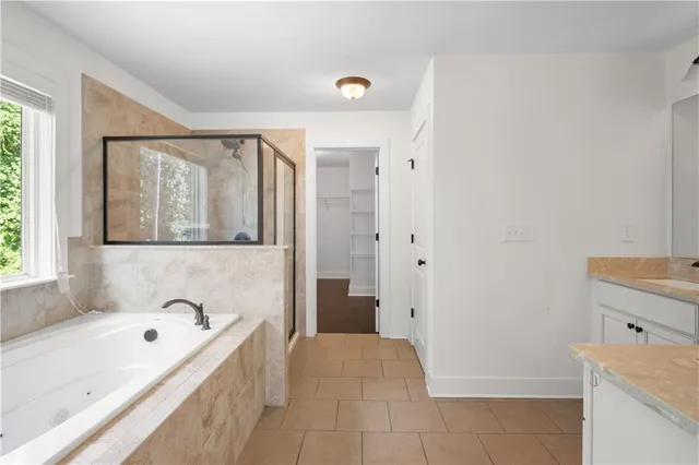 a bathroom with a tub sink and mirror