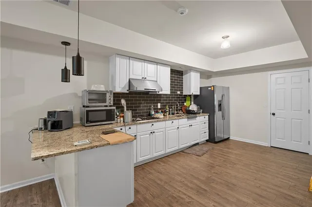a kitchen with granite countertop a refrigerator stove top oven and sink