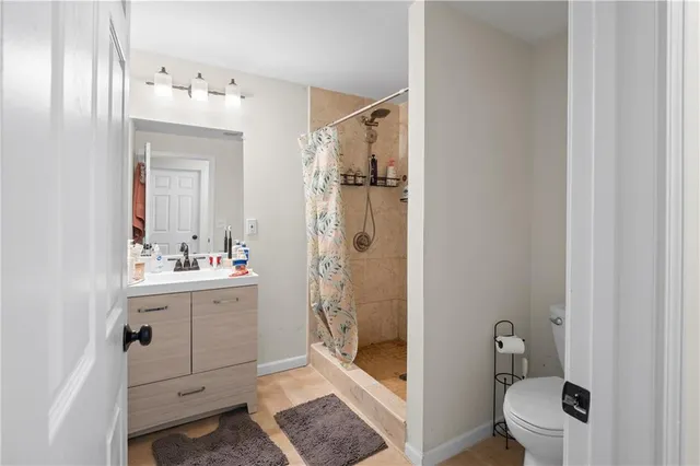 a bathroom with a sink a toilet and shower