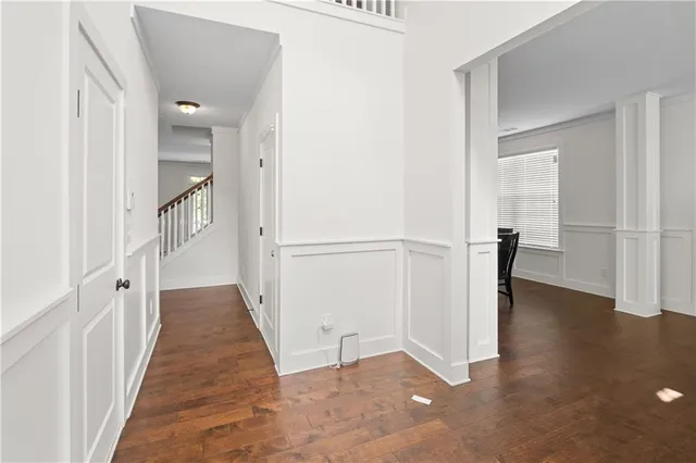 a view of a hallway with wooden floor and staircase