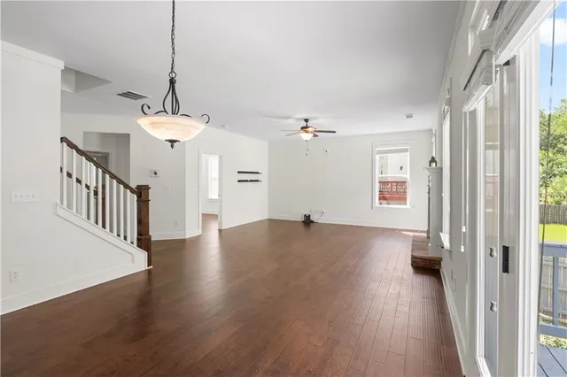 a view of a hallway with wooden floor and a chandelier