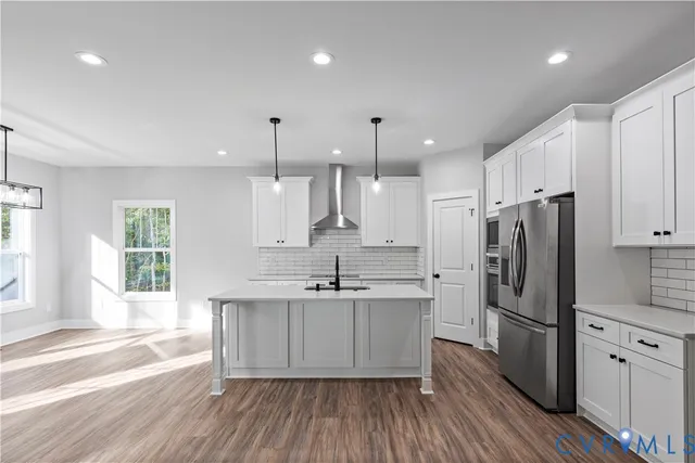 a kitchen with stainless steel appliances a sink cabinets and wooden floor