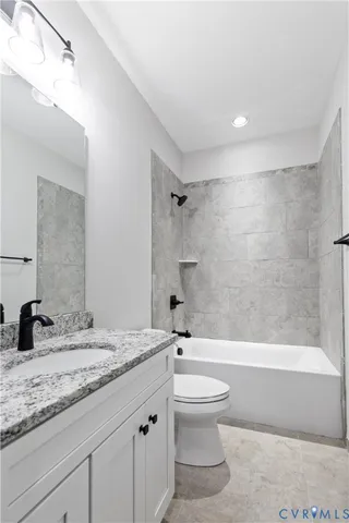 a bathroom with a granite countertop sink a toilet and shower