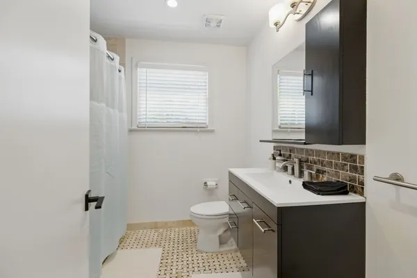 a bathroom with a sink toilet and mirror