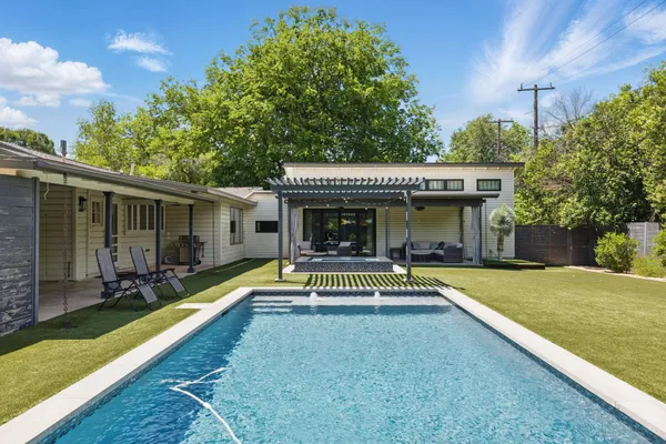 a view of a house with swimming pool and sitting area