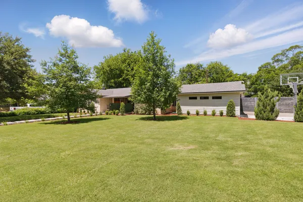 a front view of a house with a yard and trees