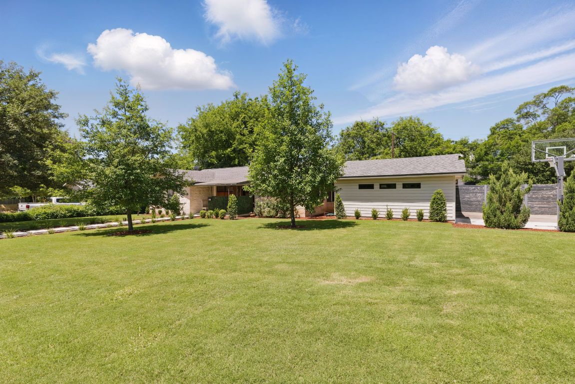6010 Nasco Drive Austin, TX 78757 - Photo 3 of 34 a front view of a house with a yard and trees