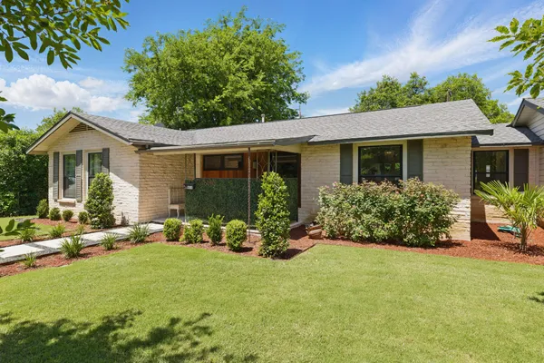 a view of a house with backyard sitting area and garden