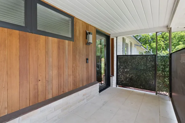 a view of a porch with wooden floor and garden