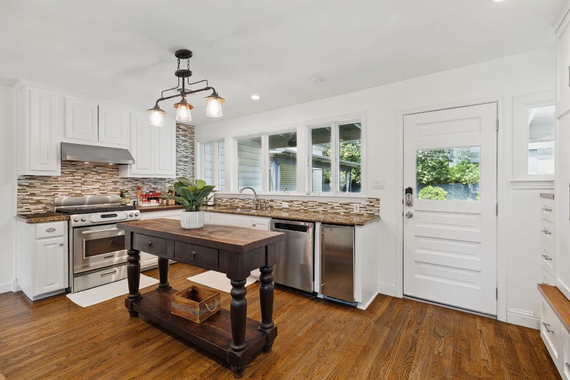 6010 Nasco Drive Austin, TX 78757 - Photo 7 of 34 a kitchen with kitchen island a counter top space a sink stainless steel appliances and cabinets