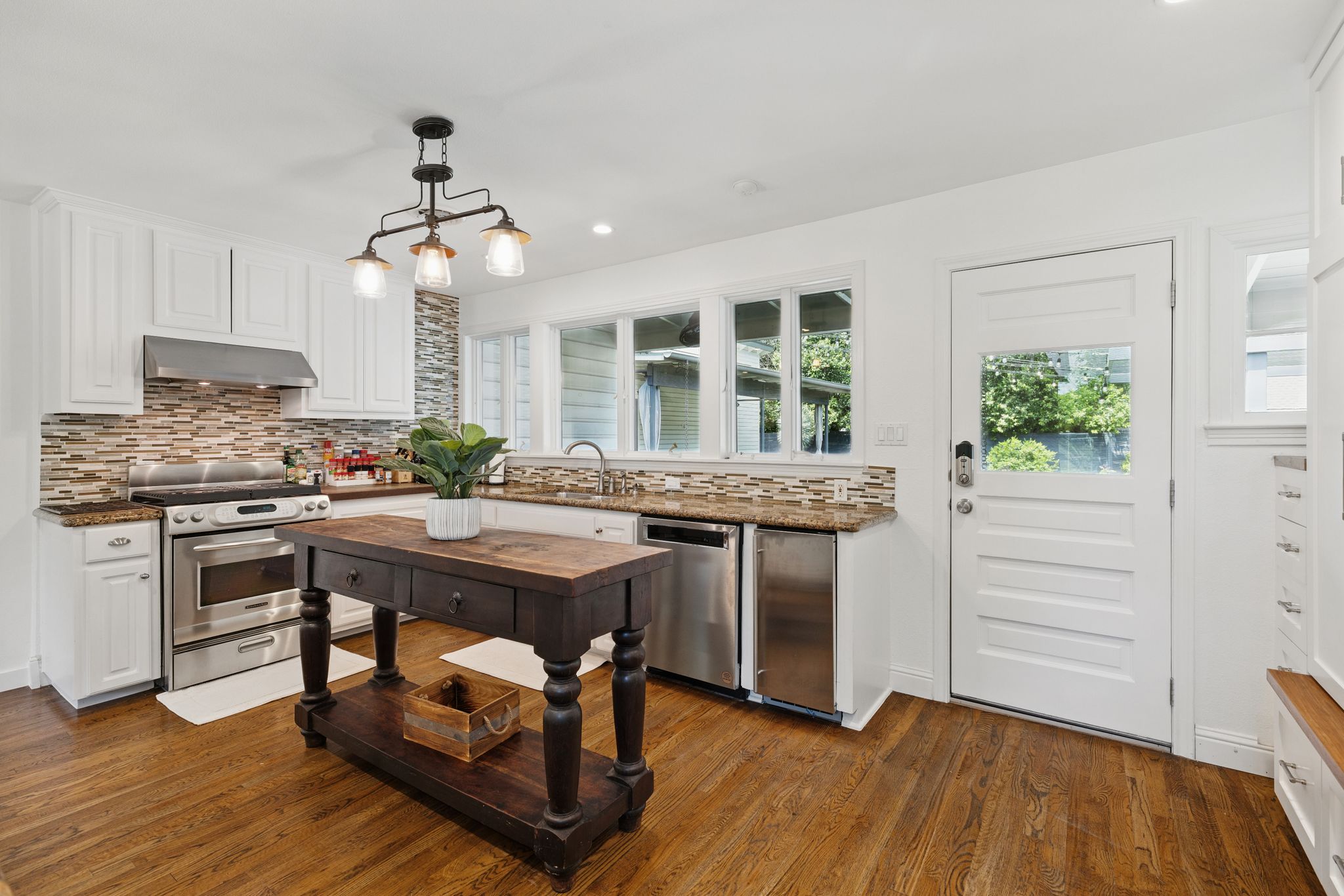 6010 Nasco Drive Austin, TX 78757 - Photo 7 of 34 a kitchen with kitchen island a counter top space a sink stainless steel appliances and cabinets