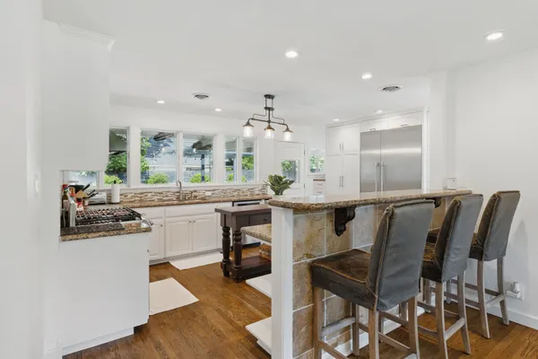 a kitchen with a dining table chairs and white cabinets