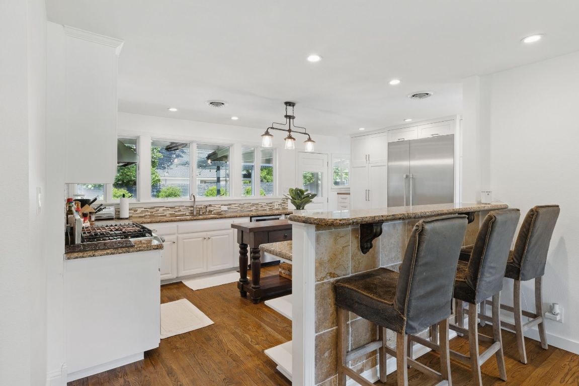 6010 Nasco Drive Austin, TX 78757 - Photo 8 of 34 a kitchen with a dining table chairs and white cabinets