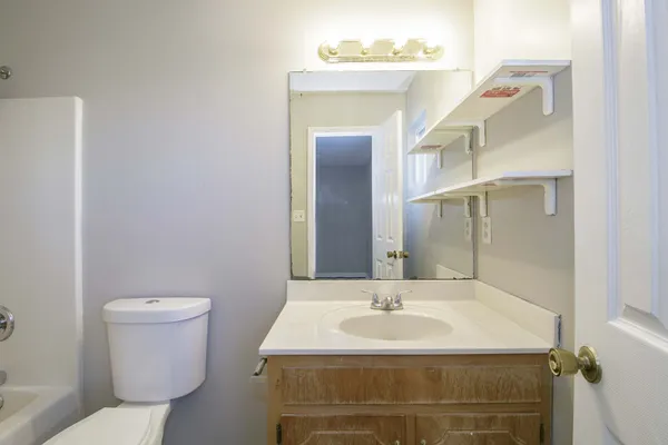 a bathroom with a sink toilet and mirror