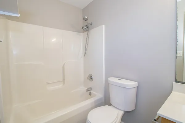a white toilet sitting next to a bath tub