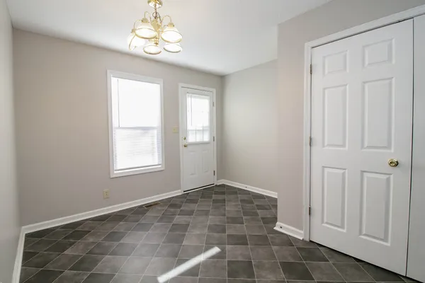 an empty room with windows and closet