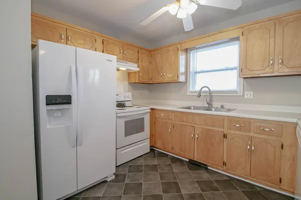 a kitchen with white cabinets and white appliances