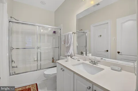 a bathroom with a double vanity sink toilet and shower