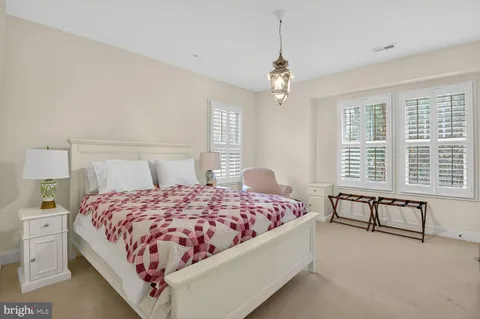 a bedroom with a large bed and a chandelier