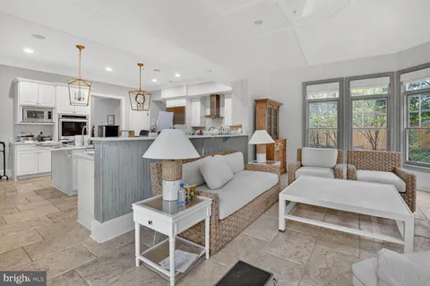 a living room with furniture and floor to ceiling windows